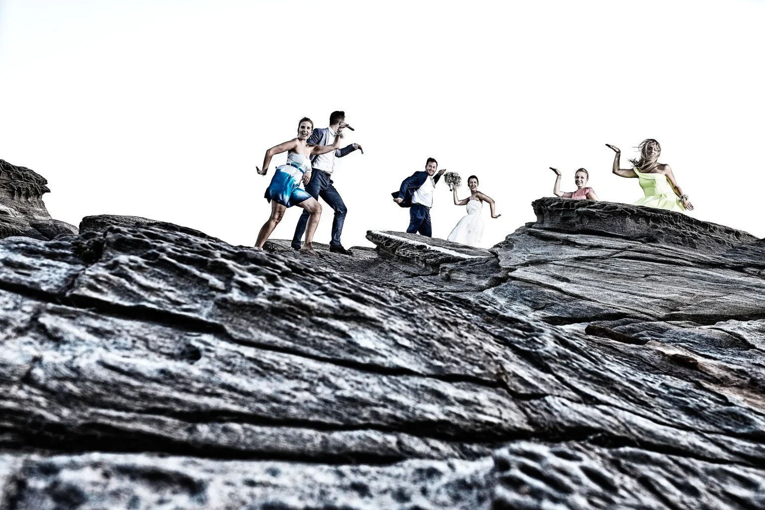 group wediing photo with best men and bridesmaids on the rocks Chrissopigi