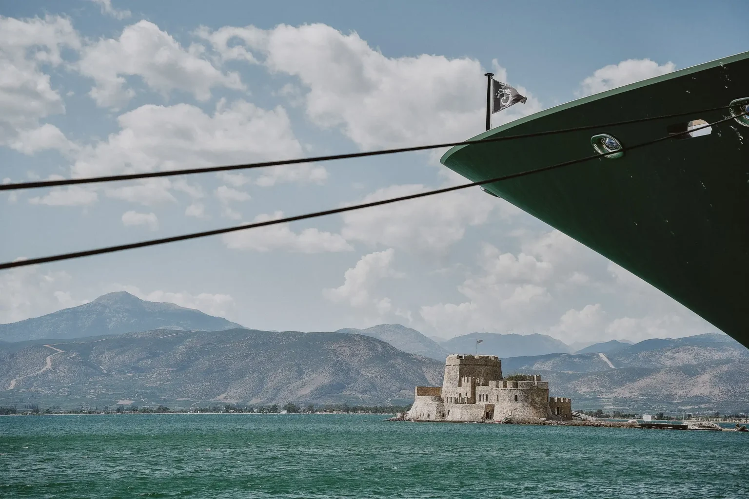 Bourtzi fortress in Nafplio harbour, framed by a moored boat and its ropes