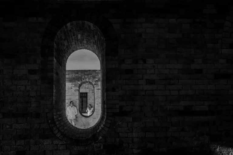 creative photo of the couple through arcs in the castle