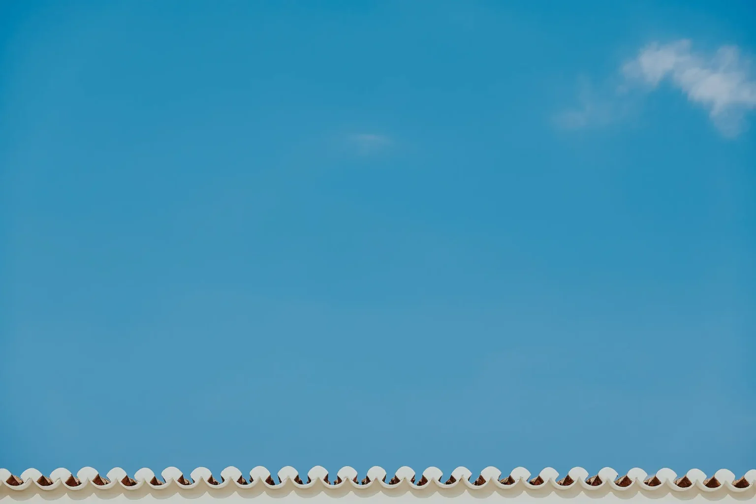 Terracotta roof tiles against a clear blue sky in Spetses.