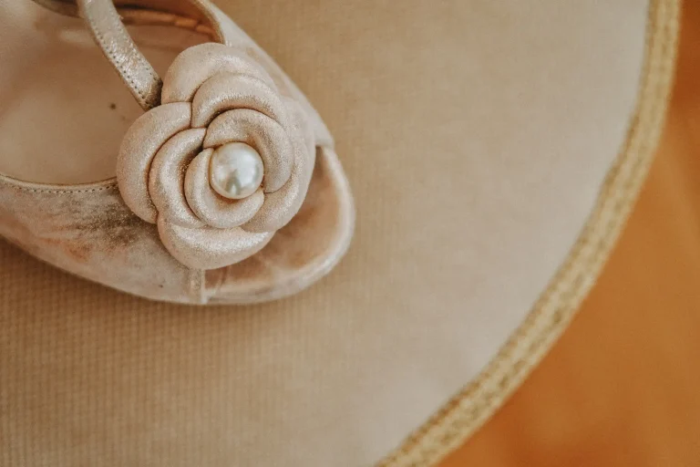 Close-up of Elena’s bridal sandal with a fabric flower and pearl detail