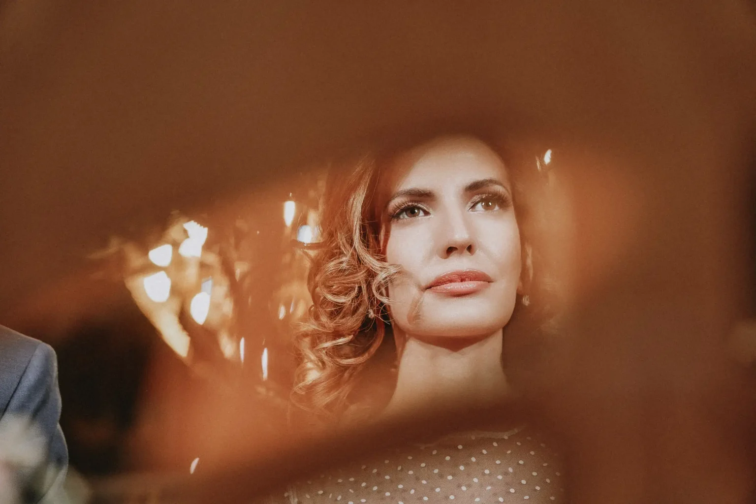 Close-up of Elena during the wedding ceremony at Agios Nikolaos, Glyfada, framed by warm blurred foreground details